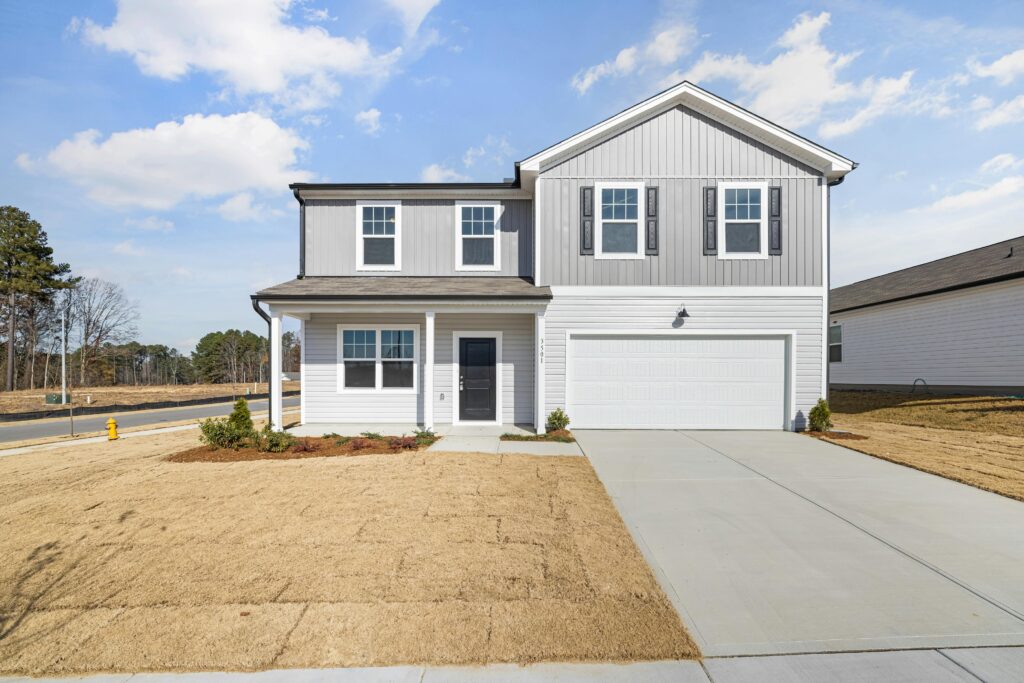 A modern two-story suburban house with a garage under a blue sky.