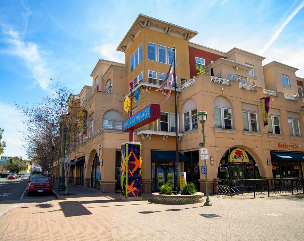 Colorful building exterior of Sunnyvale Village under a clear blue sky.